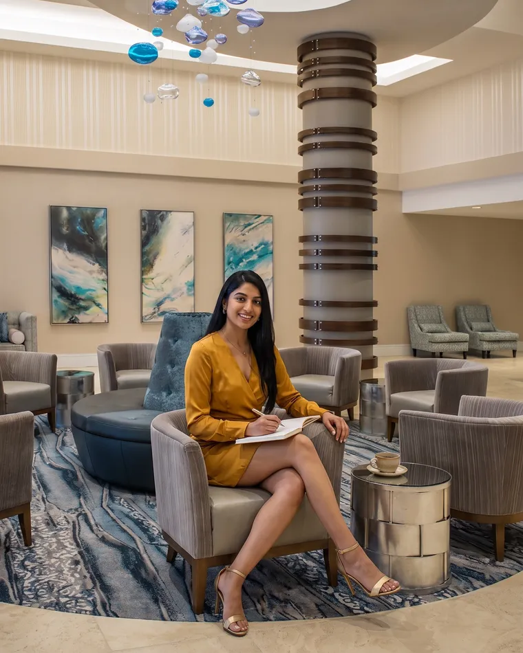 A woman in an armchair in the Temple Gardens lobby